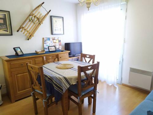une salle à manger avec une table, des chaises et une télévision dans l'établissement T2 avec ascenseur, parking privé et cabine lits superposés - FR-1-812-25, à Cauterets