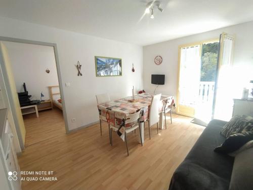 un salon avec une table et un canapé dans l'établissement Confort et Vue Montagne : Appartement 2 Chambres à Cauterets - FR-1-812-61, à Cauterets