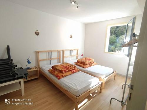 Cette chambre comprend 2 lits jumeaux et une télévision. dans l'établissement Confort et Vue Montagne : Appartement 2 Chambres à Cauterets - FR-1-812-61, à Cauterets