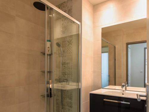 une salle de bain avec une douche en verre et un lavabo dans l'établissement Appartement rénové 3 ch, centre-ville Cauterets - FR-1-812-39, à Cauterets