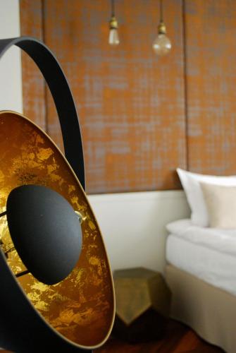 a chair with a mirror in a room with a bed at Hotel Nihil Novi in Radom