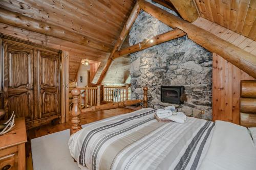 a bedroom with a bed in a room with a stone wall at Massive Rustic Waterfront Log Cabin in Stokes Bay