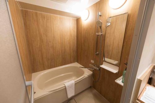 a small bathroom with a tub and a shower at Hotel Paul House in Tokyo