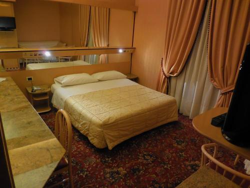 a hotel room with a bed and a table at Hotel Roma in Cesano Boscone