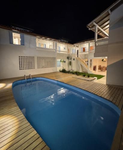 a swimming pool in the middle of a yard at night at Pousada Vilab in Arraial d'Ajuda