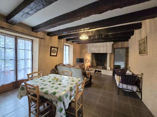un salon avec une table et une cheminée dans l'établissement Maison Périgourdine avec jardin clos, cheminée et activités nautiques à proximité - FR-1-616-15, à Coulaures