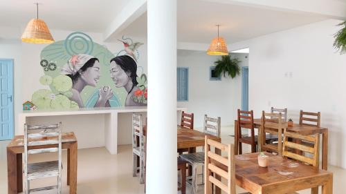 a dining room with a table and a mural at Pousada Vilab in Arraial d'Ajuda