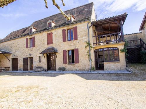 une ancienne maison en pierre avec volets rouges dans l'établissement Maison de charme à La Roque-Gageac avec jardin, terrasse et équipements bébé - FR-1-616-136, à La Roque-Gageac