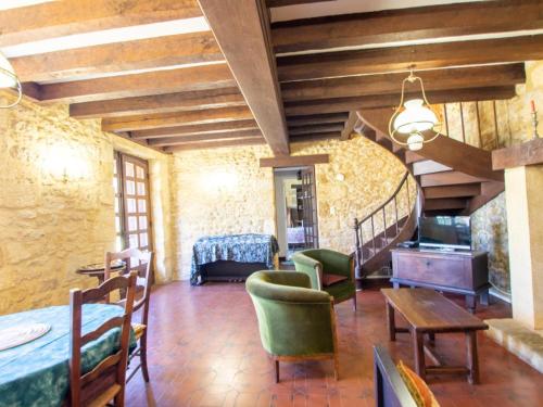 - un salon avec des plafonds en bois, une table et des chaises dans l'établissement Maison de charme à La Roque-Gageac avec jardin, terrasse et équipements bébé - FR-1-616-136, à La Roque-Gageac