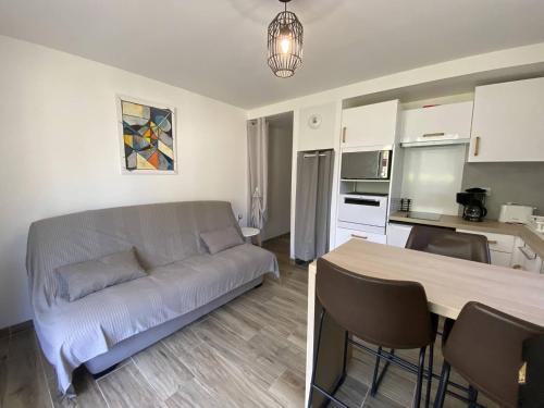 un salon avec un canapé et une cuisine dans l'établissement Appartement rénové avec terrasse et parking à Cauterets - FR-1-812-71, à Cauterets