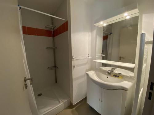 une salle de bain blanche avec un lavabo et une douche dans l'établissement Appartement cosy Cauterets, télécabine, parking, Wi-Fi, 4 pers - FR-1-812-79, à Cauterets