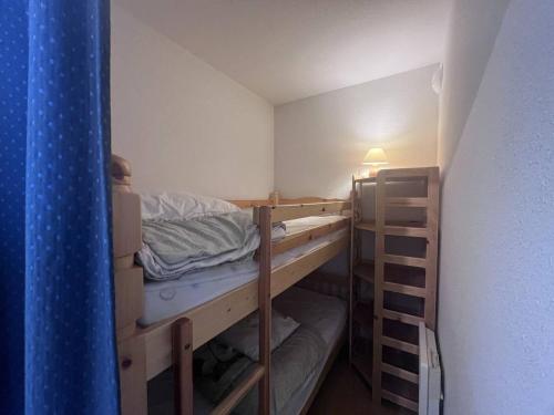 Cette petite chambre comprend 2 lits superposés et une lampe. dans l'établissement Appartement cosy à Cauterets avec terrasse et local à ski - FR-1-812-84, à Cauterets