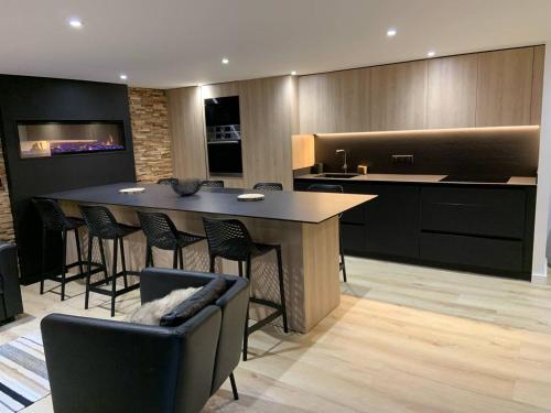 - une cuisine avec un bar avec des chaises et une table dans l'établissement Triplex moderne avec cheminée, balcon et parking à Cauterets - FR-1-812-78, à Cauterets