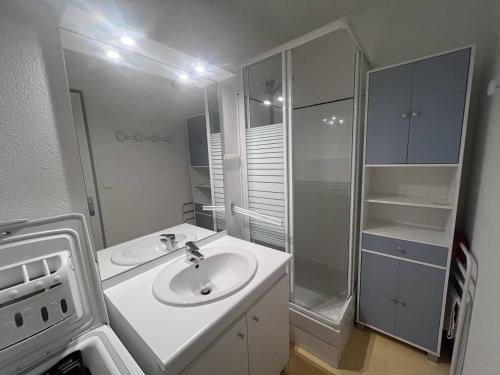 une salle de bain blanche avec un lavabo et une douche dans l'établissement Appartement cosy à Cauterets avec terrasse et local à ski - FR-1-812-84, à Cauterets