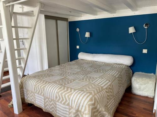 une chambre avec un lit et un mur bleu dans l'établissement Studio cosy pour 4 près des Thermes et télécabines - FR-1-812-85, à Cauterets