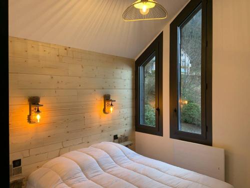 Cette chambre est dotée d'un mur, de deux fenêtres et d'un lit. dans l'établissement Triplex moderne avec cheminée, balcon et parking à Cauterets - FR-1-812-78, à Cauterets