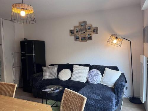 - un salon avec un canapé bleu et deux lampes dans l'établissement Appartement avec terrasse et parking, 2 chambres, au cœur des montagnes - FR-1-812-90, à Cauterets