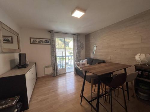 un salon avec une table et des chaises dans une pièce dans l'établissement Appartement à Cauterets avec balcon et parking privé - FR-1-812-96, à Cauterets
