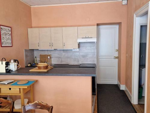 une cuisine avec des armoires blanches et un comptoir dans l'établissement Appartement cosy 6 pers, 2 chambres, Cauterets - FR-1-812-88, à Cauterets