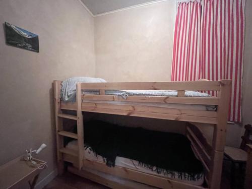 Ce lit superposé en bois se trouve dans un dortoir. dans l'établissement Appartement cosy 6 pers, 2 chambres, Cauterets - FR-1-812-88, à Cauterets