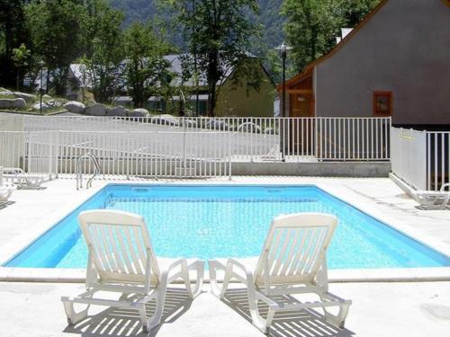 deux chaises assises à côté d'une piscine dans l'établissement Studio à Cauterets avec piscine et animaux admis - FR-1-812-94, à Cauterets