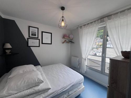 une chambre avec un lit et une grande fenêtre dans l'établissement Appartement cosy avec chambre et alcove, proche des commodités - FR-1-812-80, à Cauterets