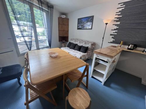 un salon avec une table en bois et un canapé dans l'établissement Appartement cosy avec chambre et alcove, proche des commodités - FR-1-812-80, à Cauterets
