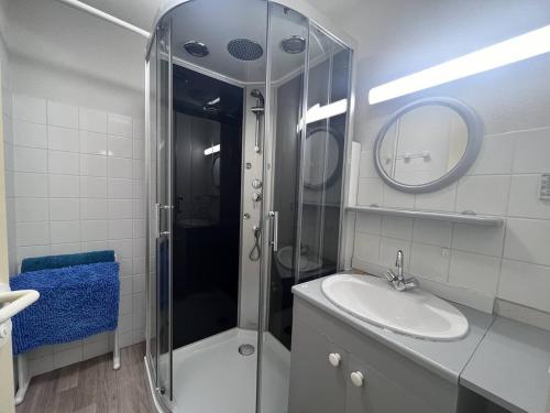 une salle de bain avec une douche, un lavabo et un miroir dans l'établissement Charmant appart 6 pers, 2 ch, à Cauterets avec parking - FR-1-812-104, à Cauterets