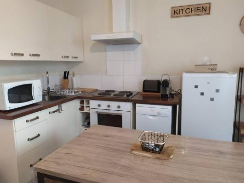 une cuisine avec un réfrigérateur blanc et une table dans l'établissement Charmant T2 à Cauterets, proximité nature - FR-1-812-99, à Cauterets