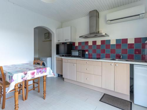 une cuisine avec une table et une cuisinière four supérieur dans l'établissement Maison calme 3 pers. proche lac & océan, terrasse & BBQ - FR-1-50-147, à Mimizan