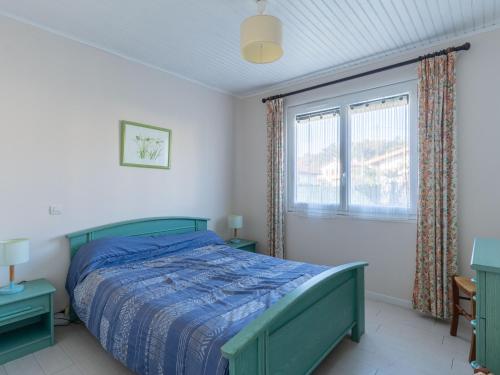 une chambre avec un lit vert et une fenêtre dans l'établissement Maison calme 3 pers. proche lac & océan, terrasse & BBQ - FR-1-50-147, à Mimizan