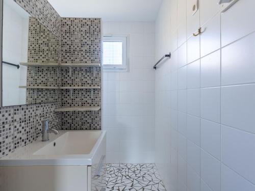 une salle de bain blanche avec un lavabo et un miroir dans l'établissement Maison calme 3 pers. proche lac & océan, terrasse & BBQ - FR-1-50-147, à Mimizan