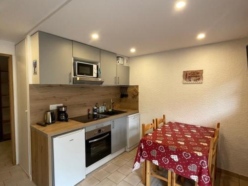 une petite cuisine avec une table et un micro-ondes dans l'établissement Studio cabine 4 pers avec Wifi et balcon à Valloire - FR-1-263-543, à Valloire