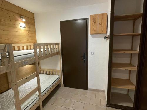 Cette chambre comprend 2 lits superposés et une porte. dans l'établissement Studio cabine 4 pers avec Wifi et balcon à Valloire - FR-1-263-543, à Valloire