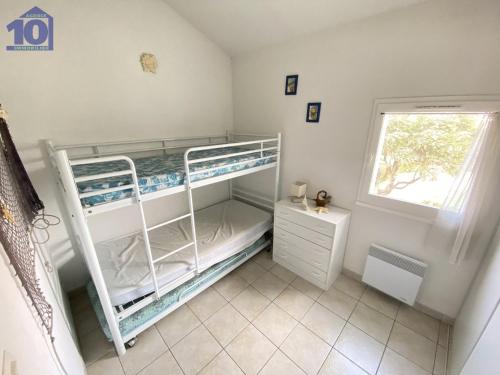 une chambre avec deux lits superposés et une fenêtre dans l'établissement Pavillon 5 pers avec piscine et parking à Valras-Plage - FR-1-781-60, à Valras-Plage