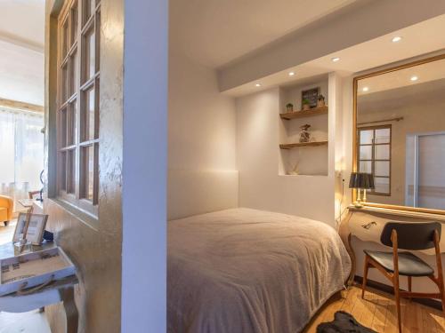 une chambre avec un lit, un bureau et un miroir dans l'établissement T2 cosy, rénové, près des thermes et randonnées - FR-1-401-309, à Cauterets