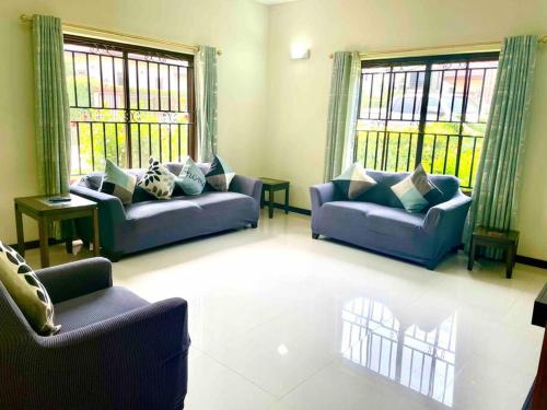 a living room with two couches and two windows at Aspen Luxury Villa in Accra