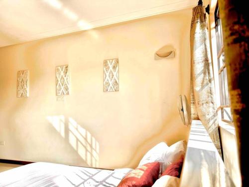 a bedroom with a bed and a window with curtains at Aspen Luxury Villa in Accra