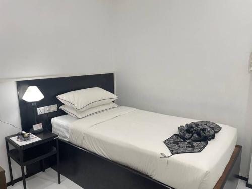 a bedroom with a large bed with a nightstand and a bed sidx sidx sidx at YAMA HOTEL & ROOFTOP BAR in Yangon