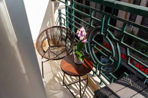 a balcony with a table and a chair and flowers at Astoria Hanoi Hotel & Travel in Hanoi