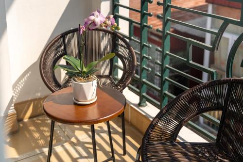 two chairs and a table with a plant on a balcony at Astoria Hanoi Hotel & Travel in Hanoi