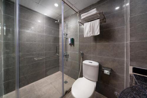 a bathroom with a toilet and a glass shower at Astoria Hanoi Hotel & Travel in Hanoi