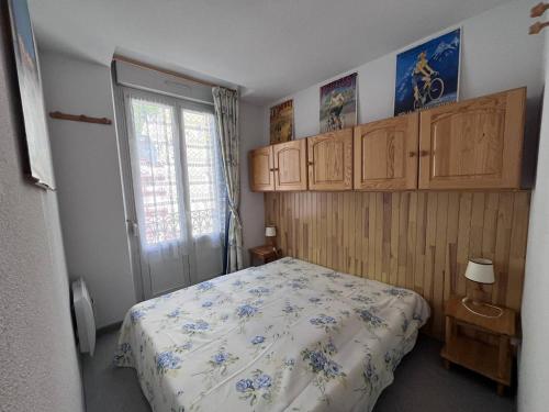 - une chambre avec un lit, des armoires en bois et une fenêtre dans l'établissement Appartement lumineux avec balcon au centre de Cauterets - FR-1-812-121, à Cauterets