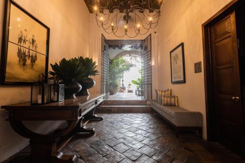 a hallway with a table and a chandelier at Casa de la Renta By Mustique in Cartagena de Indias