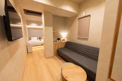 a living room with a couch and a bed at Hotel Paul House in Tokyo