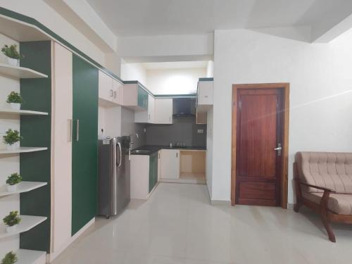 a kitchen with green and white walls and a door at Pali homes in Kottayam