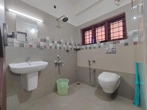 a bathroom with a sink and a toilet at Pali homes in Kottayam