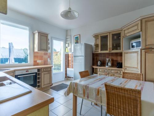 une cuisine avec une table et un réfrigérateur dans l'établissement Maison confortable pour 6 à Mimizan Plage, proche océan et pistes cyclables - FR-1-50-146, à Mimizan