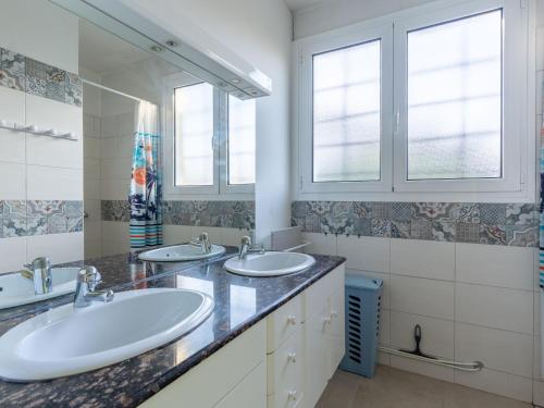 une salle de bain avec deux lavabos et deux fenêtres dans l'établissement Maison confortable pour 6 à Mimizan Plage, proche océan et pistes cyclables - FR-1-50-146, à Mimizan