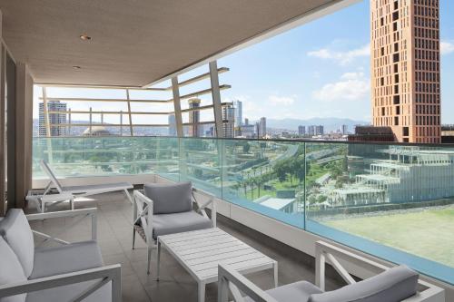 a balcony with chairs and a view of a city at Four Points by Sheraton Izmir in Izmir